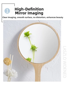 Detail view of a round handheld wooden makeup mirror with natural wood handle and clear glass