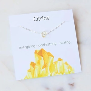 Detail view of a silver citrine crystal bead necklace on an informative white display card