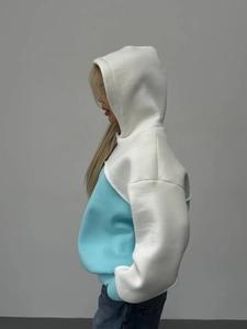 Detail of side silhouette on a two-tone oversized hoodie with ribbed cuffs and soft fabric
