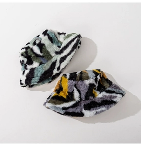 Detail of plush camouflage bucket hats in green and purple patterns with soft texture