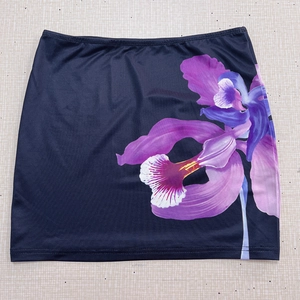 Vue à plat d'une jupe crayon bleu marine avec motif floral d'orchidée violette