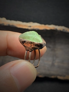 Close-up of raw green natural stone set in vintage bronze adjustable double band ring