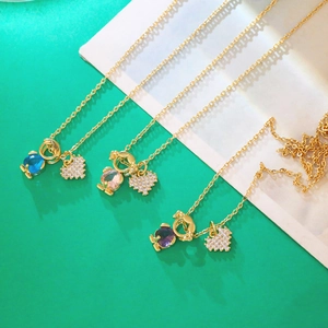 Detailed view of gold necklaces with heart and cartoon girl pendants with zircon stones