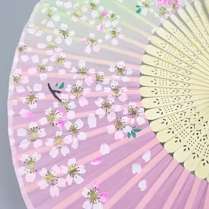 Japanese style cherry blossom folding fan with pink gradient silk and carved bamboo ribs