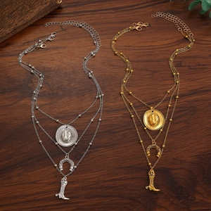 Dettaglio collana western multistrato con ciondoli a cappello, ferro e stivale