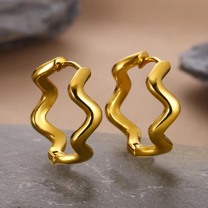Detailed view of wavy geometric gold hoop earrings with a polished metallic finish