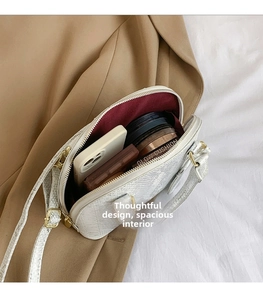 Intérieur spacieux du sac coquille blanc à motif lézard avec des objets essentiels