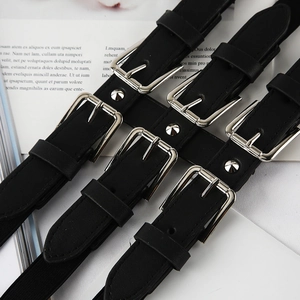 Detail of punk style black leather harness belt with silver buckles and metal studs