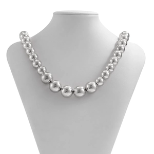 Detail of silver oversized gradient ball necklace on white bust with polished finish