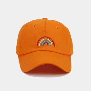 Detailed close-up of rainbow embroidery on an orange cotton baseball cap crown