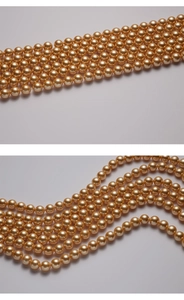 Macro view of high-quality champagne gold round pearls with smooth luster and glossy finish