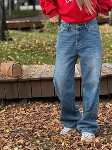 Close-up of blue wide-leg jeans with detailed denim texture in an outdoor setting