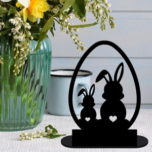 Detailed black rabbit silhouettes with heart cutouts inside an egg-shaped frame decoration