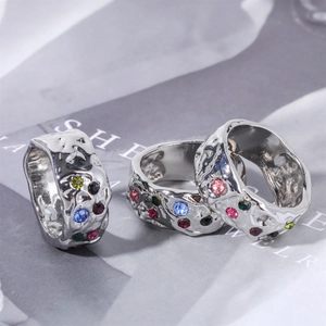 Detail of silver rings with wrinkled texture and colorful zircon inlays set on magazine