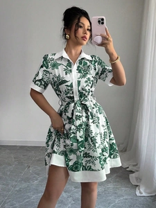 Detail of short sleeve floral shirt dress featuring button-down front and waist tie belt