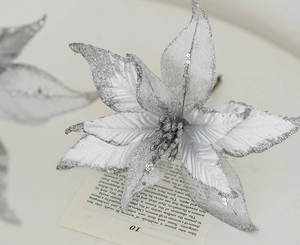 Gros plan d'une fleur de Noël artificielle argentée de 25 cm avec paillettes et brillants
