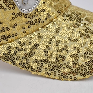 Détails de paillettes dorées et motifs en strass argentés sur la casquette en maille