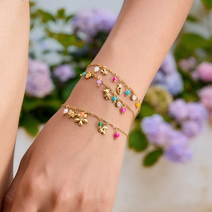 Three-piece gold-plated link bracelets with colorful beads and cute charms on a wrist