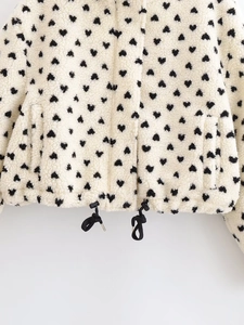 Detail des verstellbaren schwarzen Kordelzugs an einer Fleecejacke mit Herzmuster