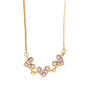 Detail of three purple crystal heart pendants on a delicate gold box chain necklace