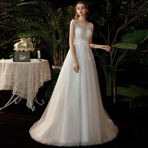 Detail of bridal gown featuring white floral lace embroidery and layered tulle skirt