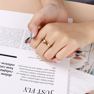 Bague cœur dorée minimaliste avec diamant blanc serti dans un décor de luxe chic