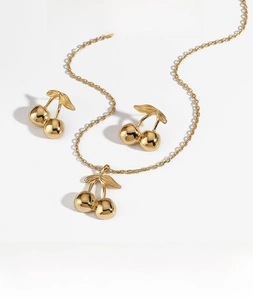 Detail of gold cherry jewelry set featuring PVD plating and hypoallergenic steel quality