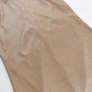 Detailed view of shimmering gold metallic fabric with fine texture and elegant draping