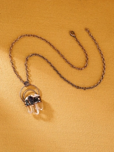 Close-up of vintage bronze chain with natural white crystals and raw amethyst pendant