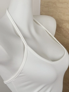 Detailed close-up of white halter neck top with high-stretch knit fabric on mannequin