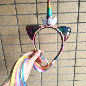 Detail of unicorn headband featuring rainbow ears and colorful long braided ponytail hair