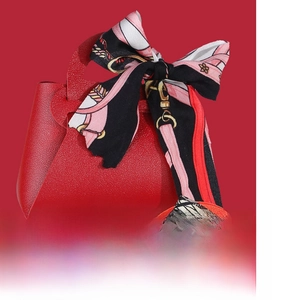 Detail of red leather wedding gift bag with a decorative floral silk scarf handle