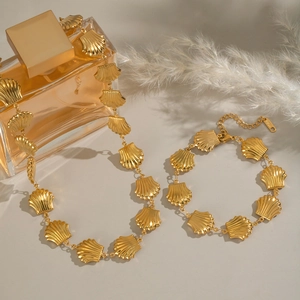 Detailed view of golden seashell necklace and bracelet set made of stainless steel