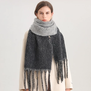 Detail showing the thick wool blend texture and gray gradient tassels on the winter scarf