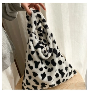 Close-up of soft cow print plush tote bag featuring black and white faux fur texture