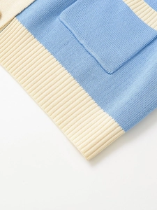 Close-up of blue and off-white knit texture and ribbed hem detail on a denim style jacket