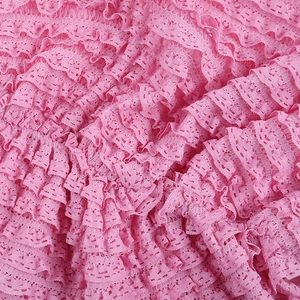 Gros plan sur le tissu jacquard rose avec dentelle délicate et détails de volants étagés