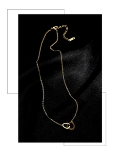 Close-up of interlocking double heart pendants on a fine gold O-chain with adjustable clasp