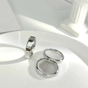 Detailed view of silver stainless steel rings with bevelled edges on a white display tray