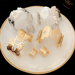 Detailed view of silver and gold ginkgo leaf and butterfly bracelet and ring jewelry set