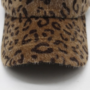 Close-up of fluffy leopard print plush fabric and curved brim of the baseball cap