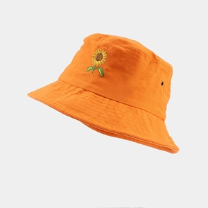 Détail de la broderie tournesol sur bob en coton orange avec œillets d'aération en métal
