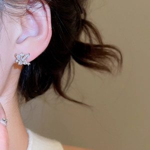 Close-up of elegant silver butterfly stud earrings with sparkling cubic zirconia on model