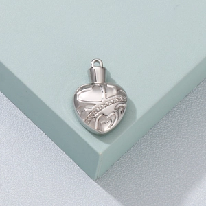 Detail shot of vintage silver heart-shaped pendant with intricate floral engravings