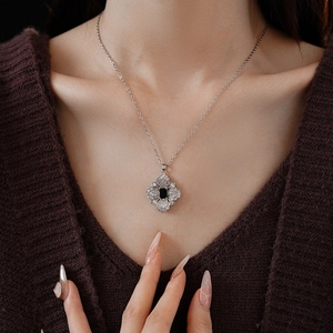 Detail of luxury necklace with black rectangular gemstone in vintage floral cross pendant