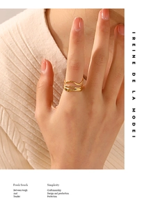 Detail of 18K gold plated triple-layer wave ring worn on finger in minimalist style