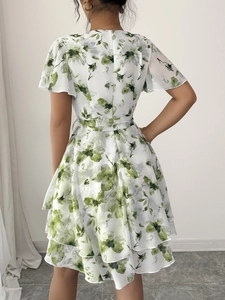 Abito lungo bianco floreale con maniche corte e balze visto dal retro per vacanza