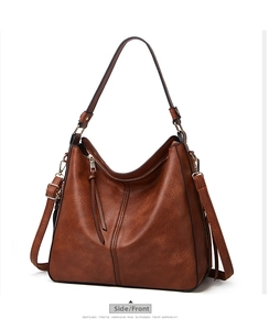 Detailed view of brown faux leather tote with dual straps and long tassel zipper puller