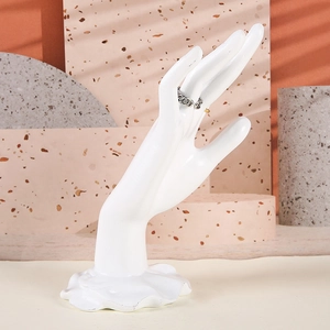 Présentoir à bijoux en forme de main en résine blanc mat pour bagues et bracelets sur terrazzo