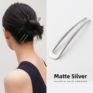 Detail view of a matte silver U-shaped metal hairpin for elegant buns and hair styling